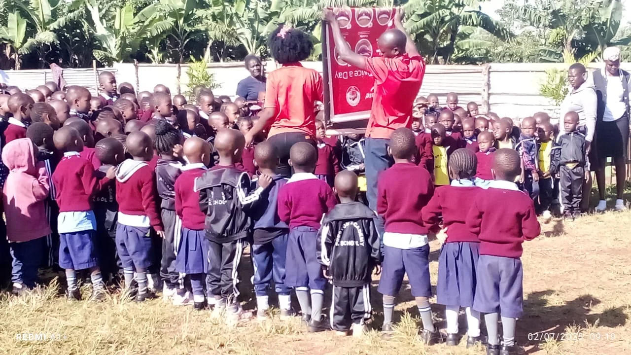 Preston Junior Academy children and community leaders gathered outdoors in Kisii, Kenya